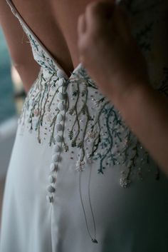 the back of a woman's dress with beading on it