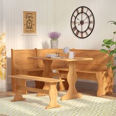 a wooden table and bench in a room with a clock on the wall behind it