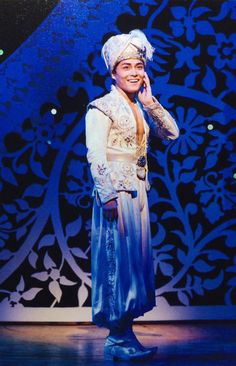 a man dressed in blue and white talking on a cell phone