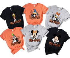 four mickey mouse halloween shirts on display in front of a white background with orange and black lettering