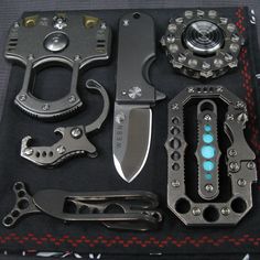 several different types of knifes and tools laid out on a black cloth with red stitching