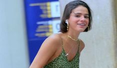 a woman in a green dress is walking down the street