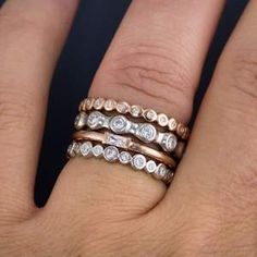 a woman's hand with three different rings on her fingers and one has a diamond in the middle