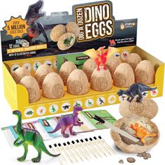 an assortment of dinosaur eggs in a cardboard box with dinosaurs and other toys around it