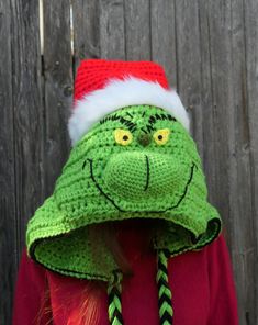 a child wearing a grin face knitted christmas hat with braids on the side