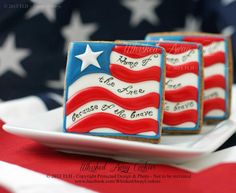 three decorated cookies on a plate with the american flag in the background and words written on them