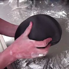 a person is making something out of dough on a pan with their hand over it