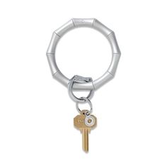 a metal keychain with two keys hanging from it's center and the end of