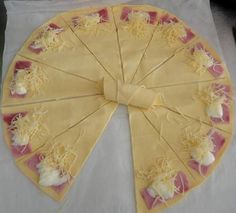 a pizza pie with cheese and other toppings on it sitting on a white table cloth