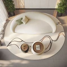 an aerial view of a living room with white furniture and potted plants on the floor