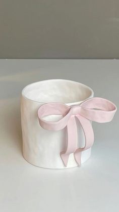 a white cup with a pink bow on it