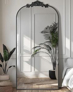 a mirror sitting on top of a wooden floor next to a potted plant