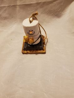 a small white cup sitting on top of a black plate with a teddy bear in it