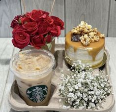 two cakes, coffee and flowers on a tray