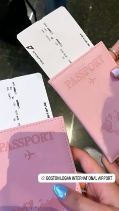 two people holding pink and white cards with the word passport printed on them in front of each other