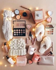 the contents of a makeup bag laid out on top of a table with lights and other items