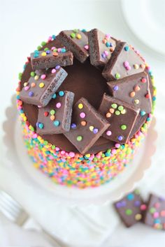 a chocolate cake with colorful sprinkles and pieces of chocolate in the middle