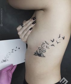 a woman's stomach with birds flying in the sky on her left side,