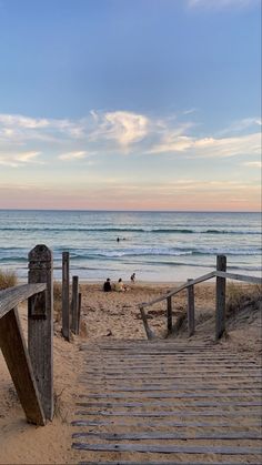 stairs leading to the beach with people in the water