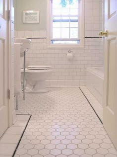 a bathroom with white tile floors and walls