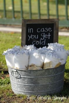 a bucket filled with money sitting on top of a grass covered field