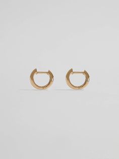 A hint of shine. Crafted from 14Kt gold, these huggie earrings are adorned with a single CZ stone that catches the light beautifully. Understated and unique, they can be worn alone or mixed with more maximalist styles. 14kt Yellow Gold 7.7mm Diameter 1.7mm Wide 1.11gr Made in Italy Materials Globally Sourced Classic 14k Rose Gold Huggie Earrings, Classic Rose Gold 14k Huggie Earrings, Luxury 14k White Gold Huggie Earrings, Tarnish Resistant White Gold Huggie Diamond Earrings, Tarnish-resistant White Gold Huggie Diamond Earrings, Classic 14k Gold Tarnish Resistant Huggie Earrings, Classic Round Huggie Earrings Tarnish Resistant, Timeless Yellow Gold Huggie Earrings Tarnish Resistant, Timeless 14k Yellow Gold Huggie Earrings