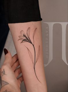 a woman's arm with a flower tattoo on the left side of her arm