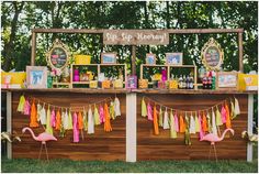 the dessert table is decorated with pink flamingos and tassels for guests to eat