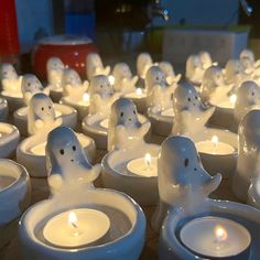 many white candles with ghost faces on them are lit in the shape of toilet bowls