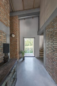 an empty room with brick walls and a door leading to a balcony area that has a potted plant in it