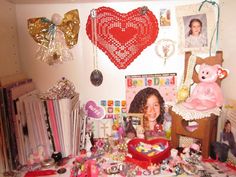 a room filled with lots of different items and pictures on the wall next to a teddy bear