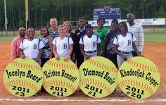 a group of young women standing next to each other on top of a baseball field