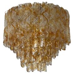 a large glass chandelier with many pieces of yellow colored material hanging from the ceiling