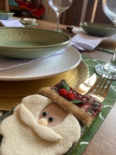 a christmas themed table setting with a teddy bear napkin holder and silverware on it