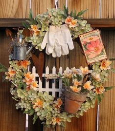 a wreath with flowers and gardening implements hanging on a wooden fence next to a potted plant