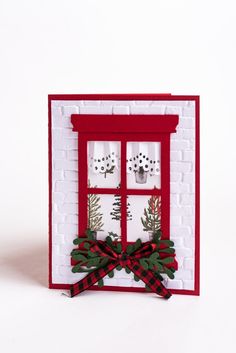 a red and white card with a bow on it's side, decorated with christmas decorations