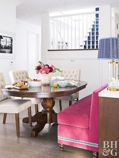 a dining room table with pink chairs and white walls