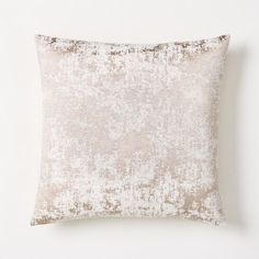 a white and beige pillow on a white wall