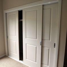 an empty room with two white doors in it