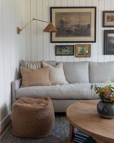 a living room filled with furniture and pictures on the wall above it's coffee table