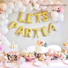 a table topped with lots of balloons and desserts