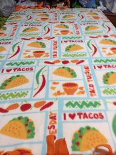 the table cloth has tacos on it and is next to a stuffed animal toy