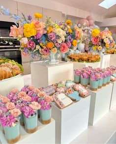 there are many desserts on the table with flowers in vases next to them