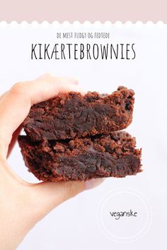 a hand holding two chocolate brownies in front of the camera with text overlay