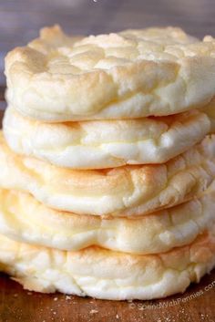 a stack of white cookies sitting on top of a wooden table