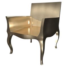 a chair that is made out of metal and has a gold finish on the back