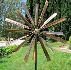 a metal and wood sculpture in the grass