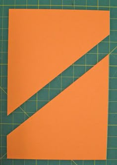 an orange piece of paper sitting on top of a cutting mat