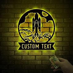 a person holding a remote control in front of a brick wall with the words custom text on it