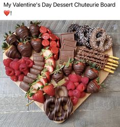 a heart shaped platter filled with chocolates, strawberries and pretzels